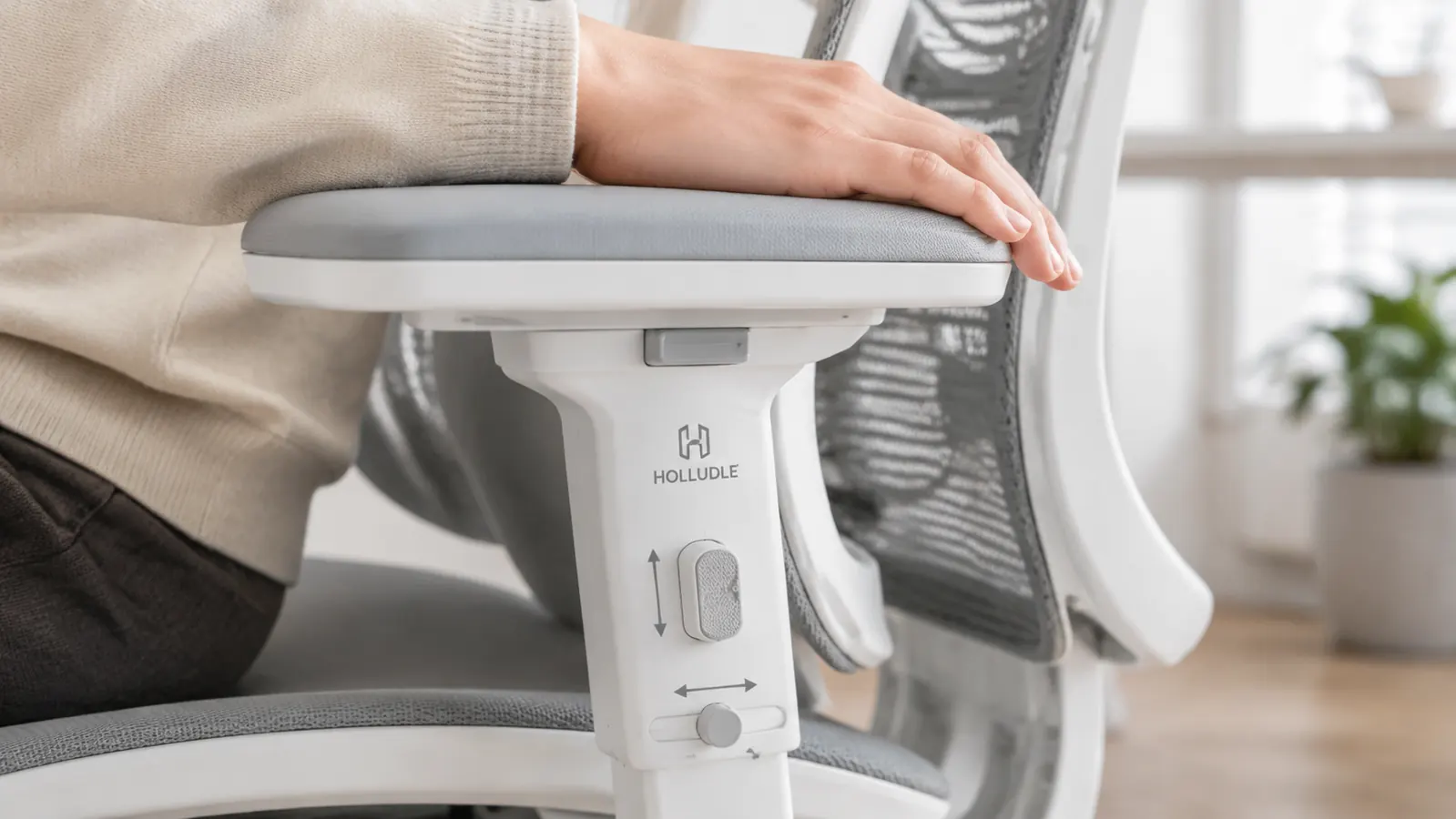 Close-up of ergonomic chair armrest adjustment mechanism with a hand demonstrating 3D range of motion