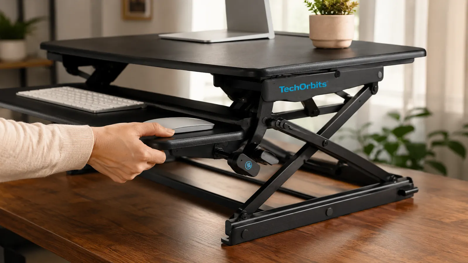 Close-up of hands adjusting the TechOrbits desk converter lever mechanism while the platform rises